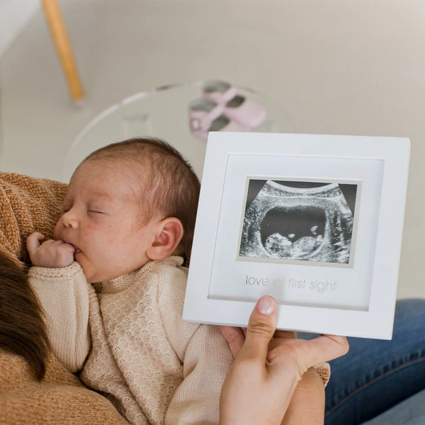 Celebrate your bundle of joy with Pearhead's sonogram frame! Comes with an easel and sawtooth hanger, plus an acid-free beveled mat for your precious 3" x 4" photo. The white frame features a silver foil stamp saying "love at first sight". Crafted from wood and standard glass, it measures 7" W x 6.75" H x .5" D and comes in packaging measuring 7.25" W x 7" H x 1.13" D.. Ships to Canada and the US Duty Free.